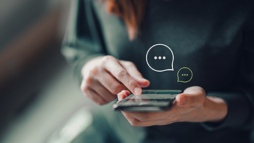 woman scrolling thrpugh phone with texting icons