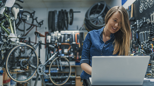 Woman working on computer in bike shop